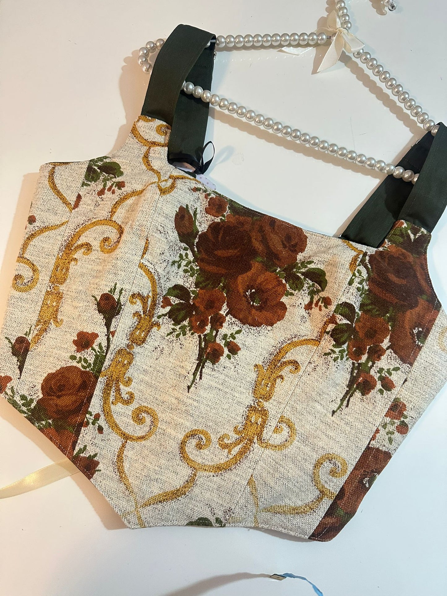 Decorative corset top with floral and gold pattern on a white background