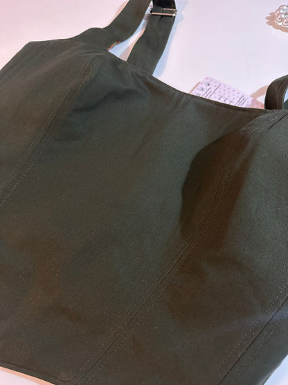 Green corset top on a light pink background