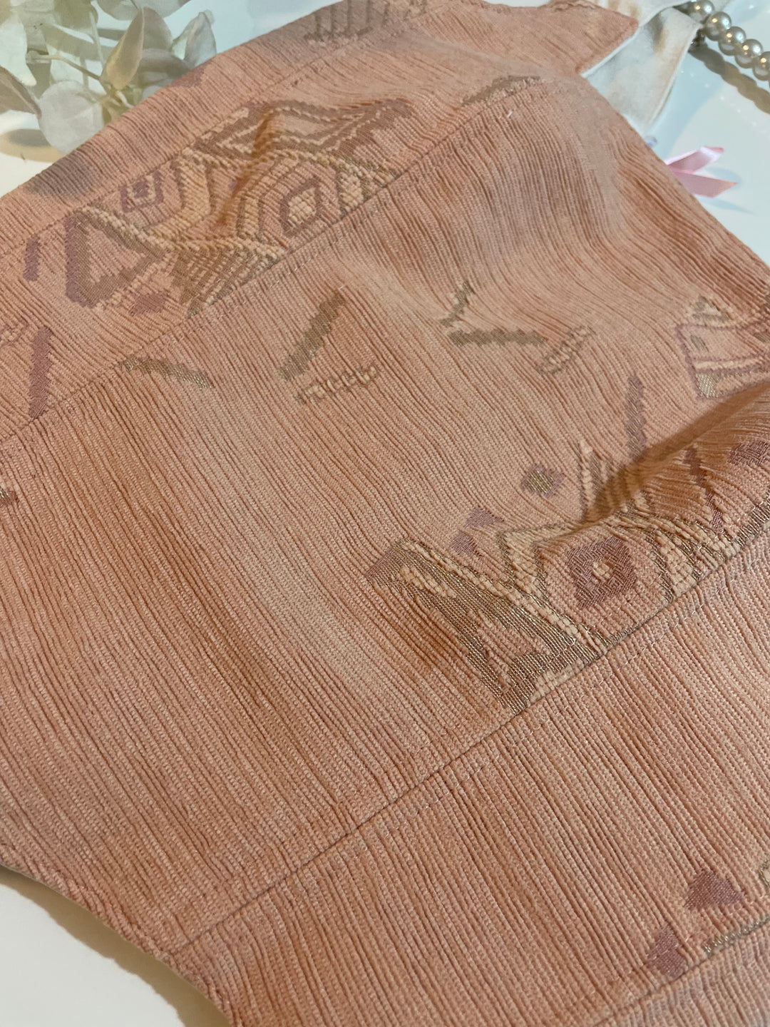 Close-up of a corset top with textured brown fabric with geometric patterns