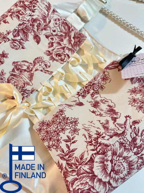 Floral-patterned croset top with ruffled edge and ribbon on a white fabric background