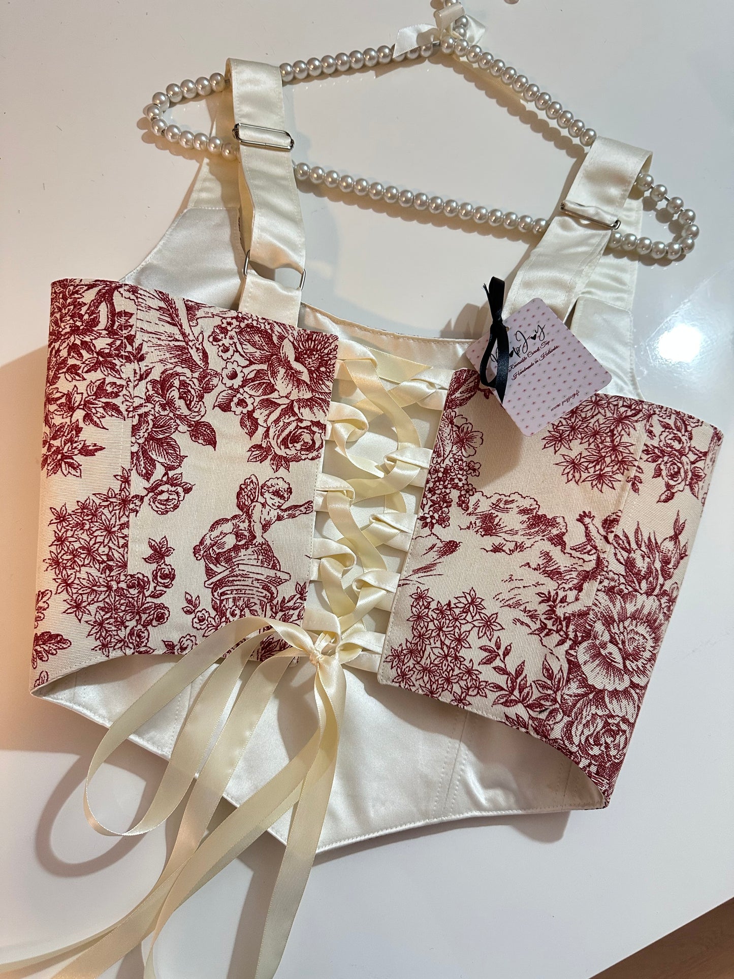 Floral-patterned corset top with a white bow and ribbon on a light background