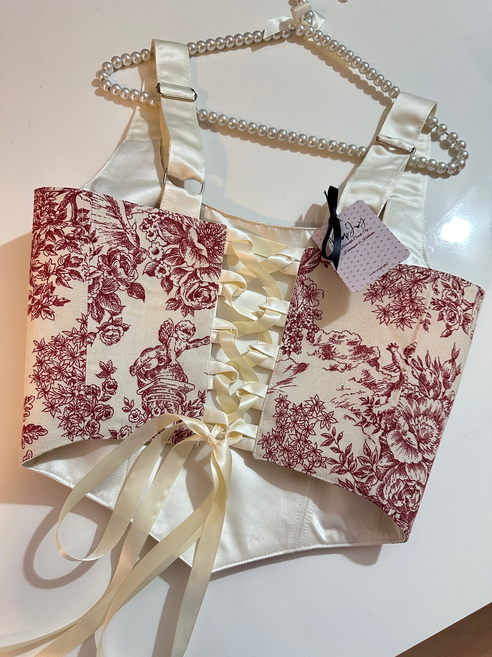 Floral-patterned corset top with a white bow and ribbon on a light background