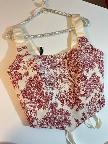 Floral-patterned corset top with a white strap on a white background