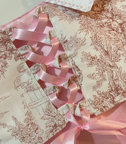 Toile de Jouy fabric with pink ribbons on a white background