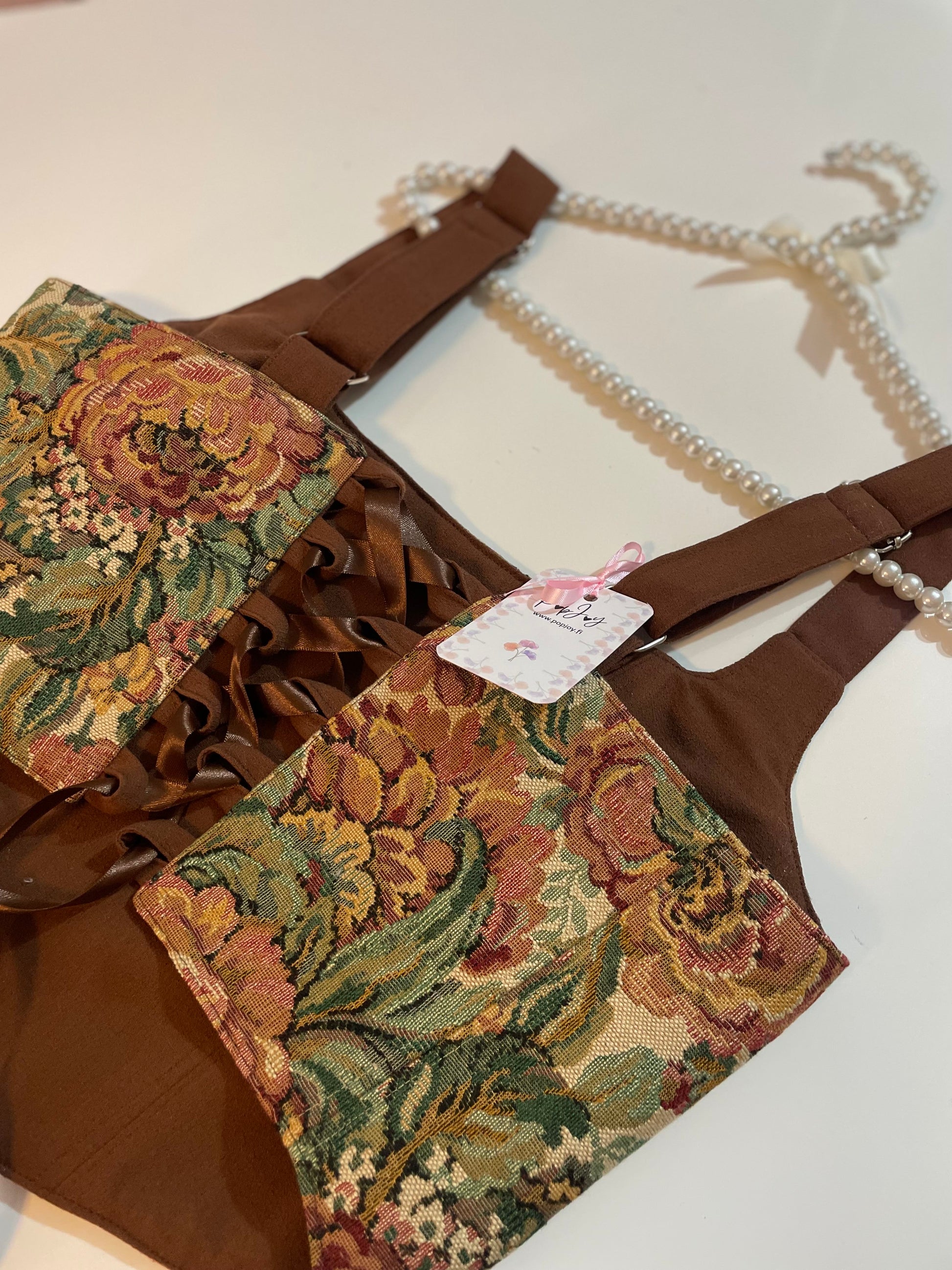 Brown corset top with floral patterns on a white background