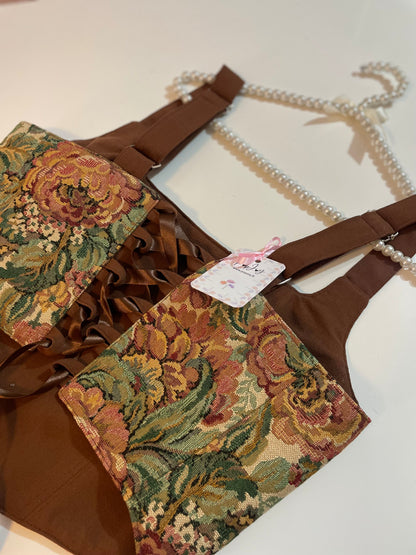 Brown corset top with floral patterns on a white background