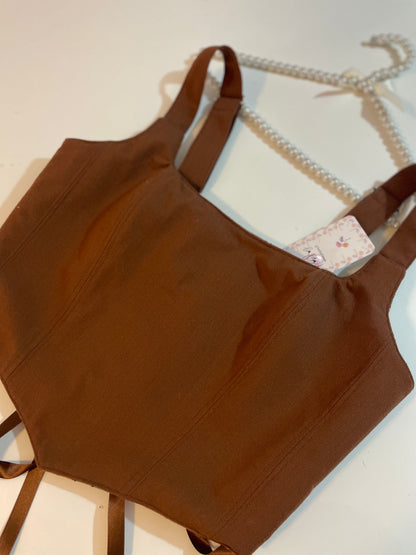 Brown corset top on a white background