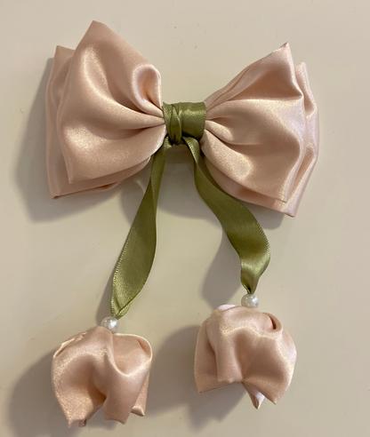 Champagne satin bow with green ribbon on a beige background