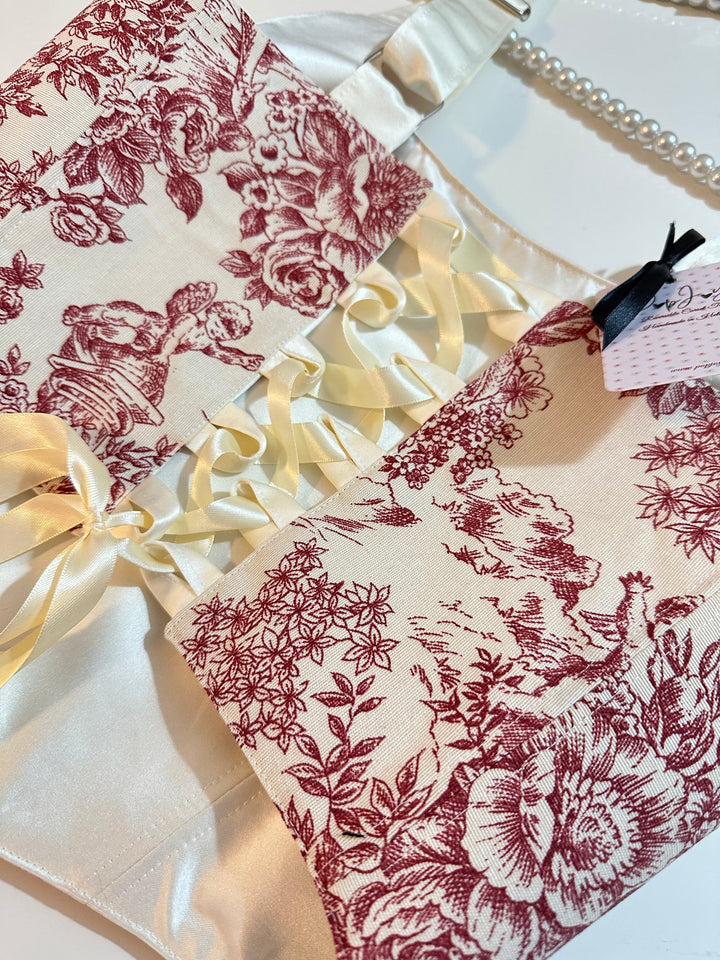 Floral-patterned croset top with ruffled edge and ribbon on a white fabric background